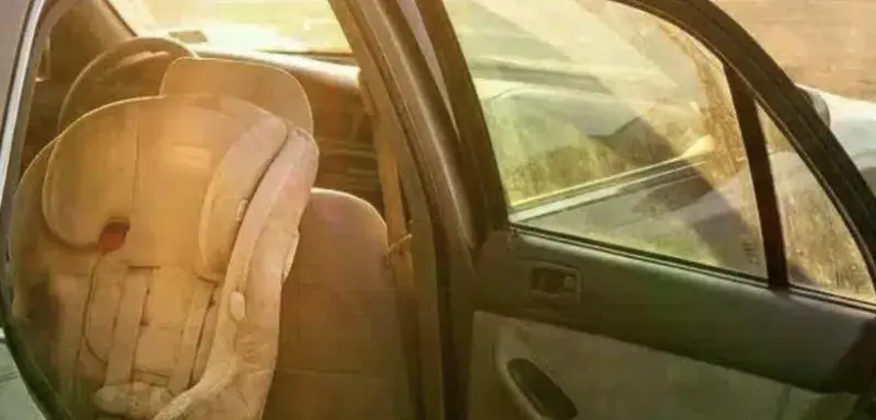Siège auto vide dans une voiture garée en plein soleil pendant la canicule à Marseille