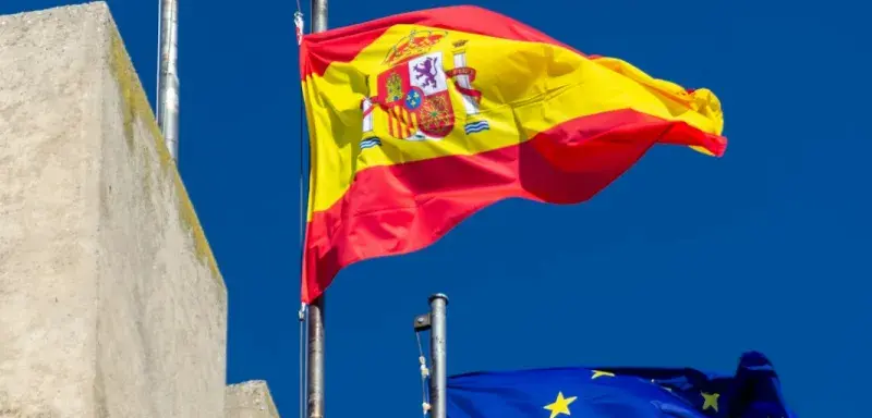 Drapeaux espagnols flottant au vent sous un ciel ensoleillé