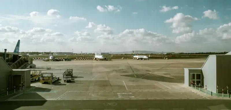 Vue du terminal et de la piste de l'aéroport avec des avions sous un ciel nuageux