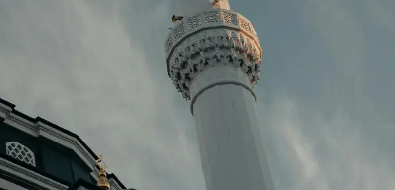 Minaret de mosquée sous un ciel nuageux, symbole du mois sacré du Ramadan