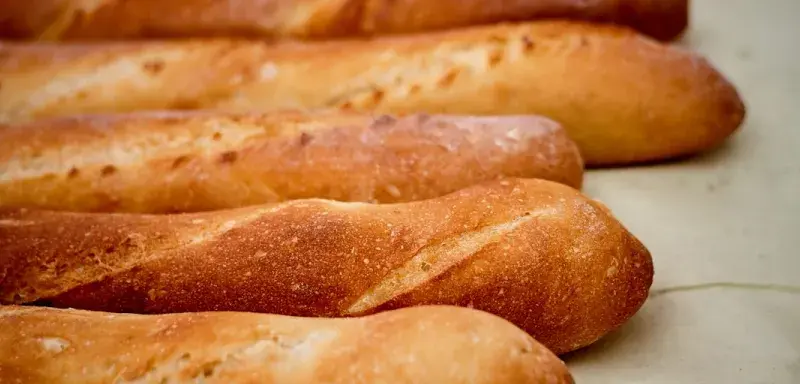 Baguettes de pain dorées alignées en boulangerie