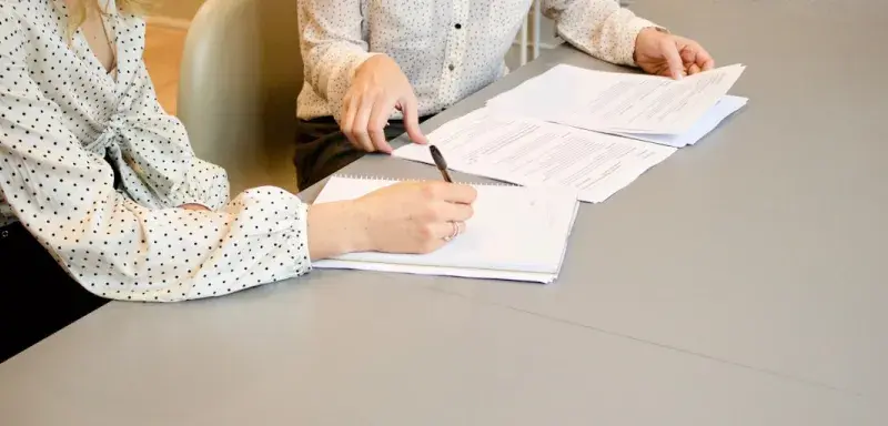 Une femme signant des documents administratifs dans un bureau