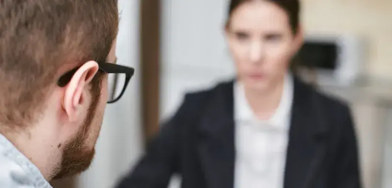 Professionnels discutant dans un bureau moderne, illustrant le recrutement assisté par intelligence artificielle