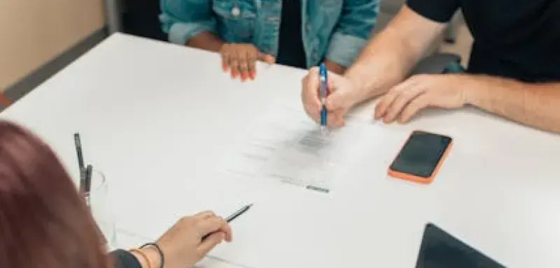 Un couple discute de documents d'adoption avec un professionnel dans un bureau