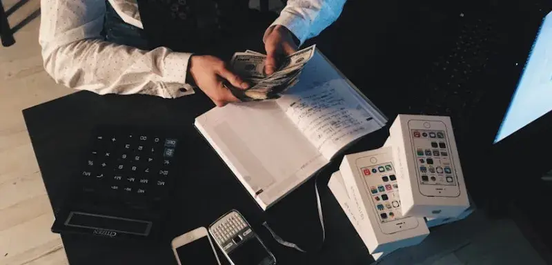 Homme d affaires organisant ses finances avec des appareils technologiques et de l argent liquide sur un bureau