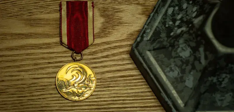 Une médaille d'or avec un ruban rouge et blanc