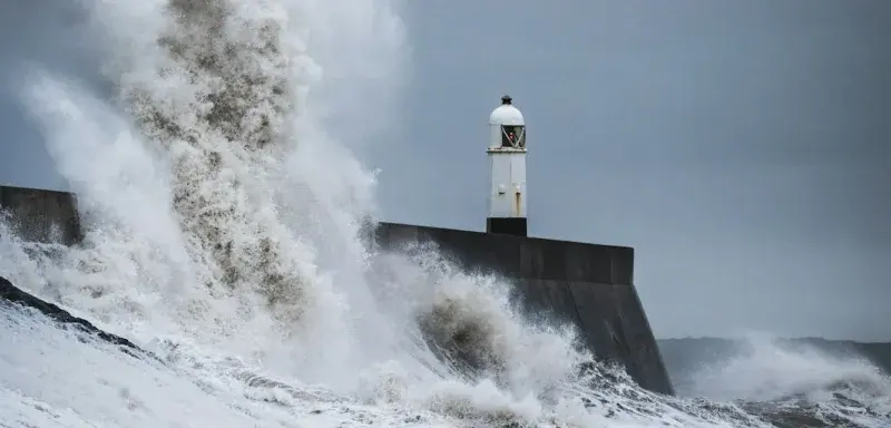 Vagues puissantes se brisant sur un phare en pleine tempête