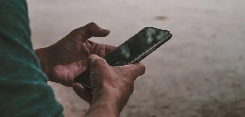 Une personne tenant un téléphone portable entre ses mains
