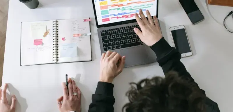 Deux personnes collaborant devant un ordinateur portable dans un bureau moderne