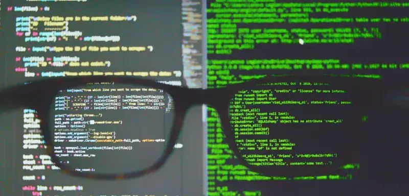 Lunettes posées sur un écran d'ordinateur affichant du code