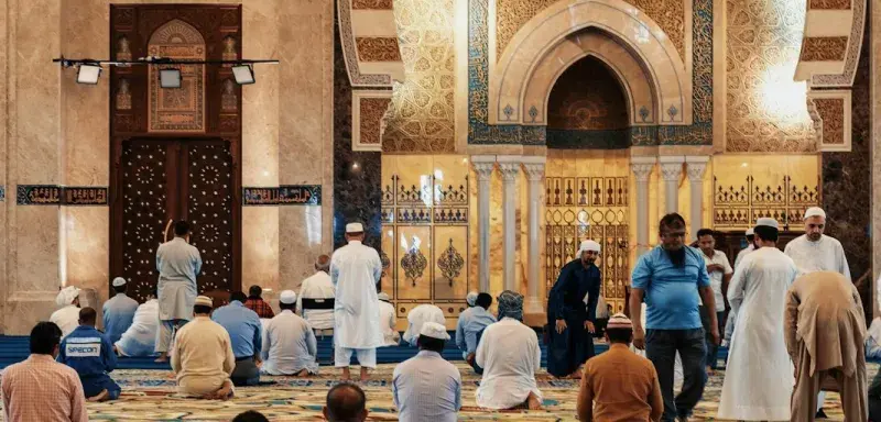 men kneeling and bowing inside building