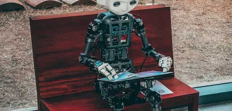 robot miniature noir et blanc sur table rouge en bois