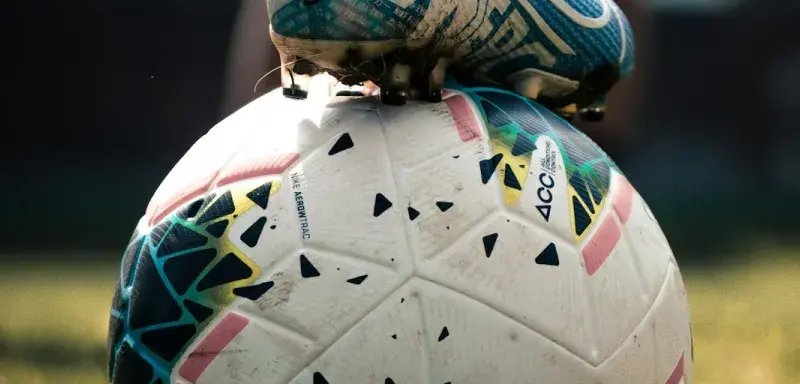 white and blue soccer ball on green grass field