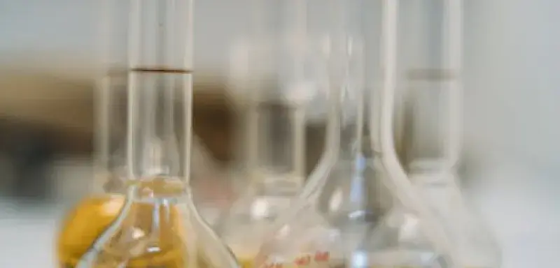 Close-up of various vials with liquids on a lab table.