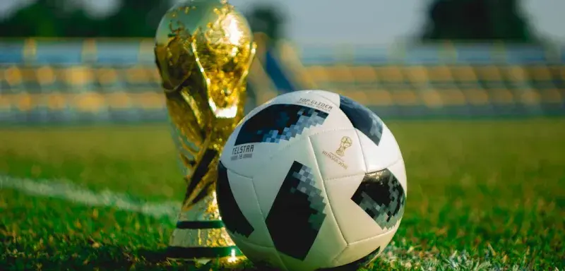 Ballon de football et trophée sur un terrain, illustration Coupe du monde