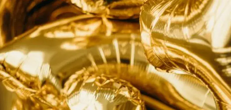 Close-up of metallic gold balloons shaped as numbers, ideal for festive occasions.