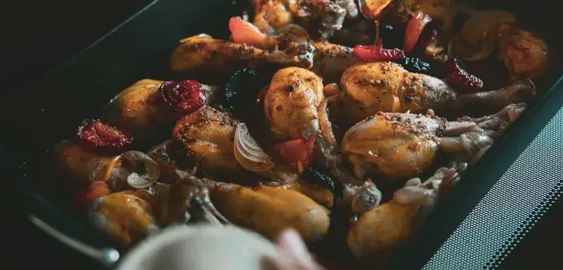 a person is spooning something into a pan of food