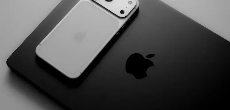 Silver smartphone resting on a black laptop