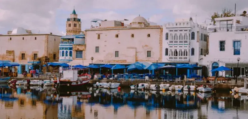 Picturesque harbor in Bizerte, Tunisia with traditional white buildings and boats.