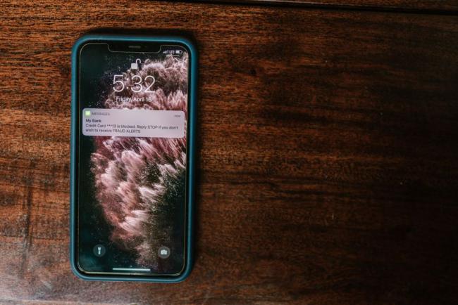 Smartphone posé sur une table affichant une alerte de la banque