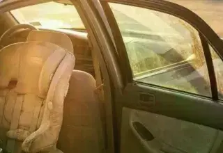 Siège auto vide dans une voiture garée en plein soleil pendant la canicule à Marseille