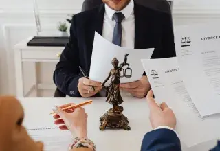 Professionnels examinant des documents dans un bureau avec une statue de la Justice