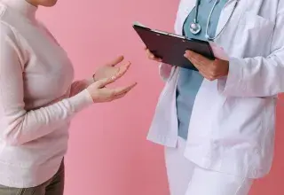 Consultation médicale entre un patient et un médecin tenant un dossier médical