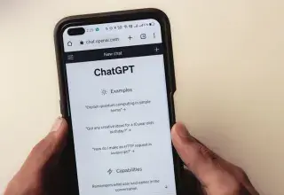 Gros plan sur des mains tenant un smartphone affichant l interface de l application ChatGPT