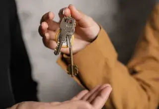 Deux adultes échangeant des clés de maison, symbole de transfert de propriété ou de contrat de location
