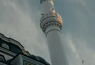 Minaret de mosquée sous un ciel nuageux, symbole du mois sacré du Ramadan
