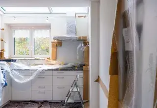 Travaux de rénovation dans une pièce lumineuse avec parquet et fenêtres