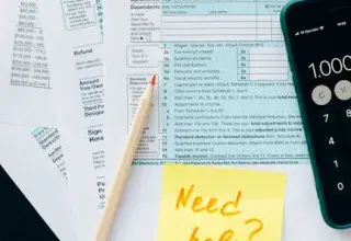 Gros plan sur des formulaires fiscaux avec une calculatrice et un mot demandant de l'aide