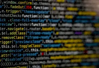Écran affichant du code informatique en jaune et bleu, symbole de cyberattaque