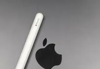 Gros plan sur un Apple Pencil posé sur un MacBook, illustrant les accessoires technologiques Apple