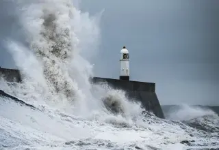 Vagues puissantes se brisant sur un phare en pleine tempête
