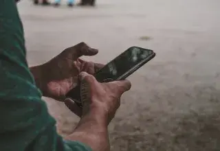 Une personne tenant un téléphone portable entre ses mains