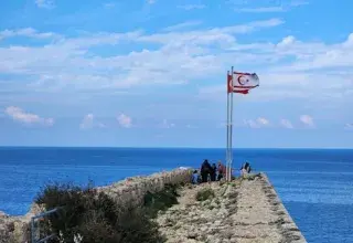 Le château historique de Kyrenia avec des drapeaux surplombant la mer par une journée ensoleillée