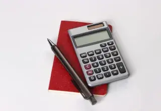 black and silver calculator beside black pen