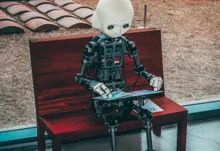 robot miniature noir et blanc sur table rouge en bois