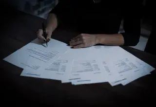 Une femme assise à une table avec de nombreux documents
