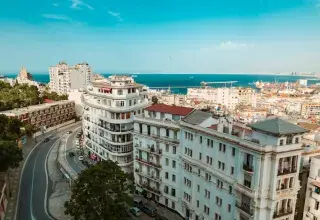 A stunning aerial view of Algiers featuring white buildings and the Mediterranean Sea.