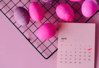 Œufs de Pâques colorés sur un support et calendrier d'avril 2021, symbolisant la célébration du printemps