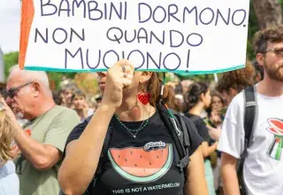 Manifestante brandissant une pancarte lors d'une protestation contre la politique migratoire en Italie
