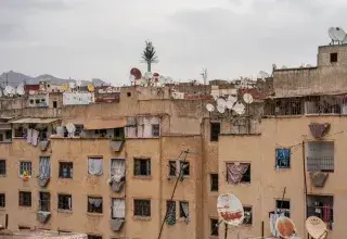 View of rooftops in Fes, Morocco, highlighting satellite dishes and urban texture.