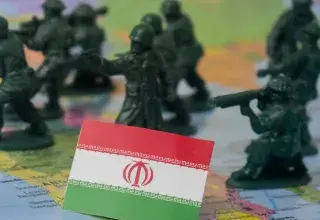 Toy soldiers surround the flag of iran on a map.