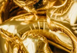 Close-up of metallic gold balloons shaped as numbers, ideal for festive occasions.