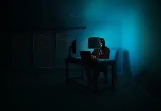 man siting facing laptop
