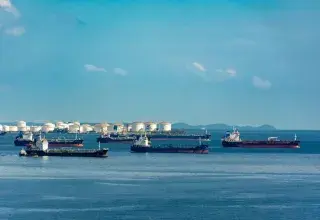 Cargos amarrés près de cuves de stockage de pétrole sur un littoral