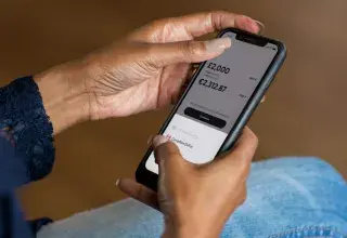 Une femme tenant un smartphone, application bancaire