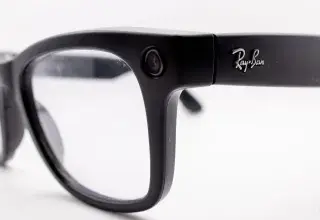 Gros plan sur la monture noire de lunettes connectées avec l'objectif de caméra intégré près de la charnière